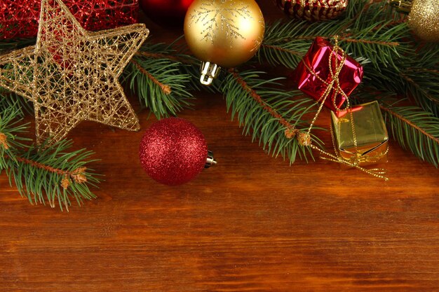 Beautiful Christmas decorations on fir tree on wooden background