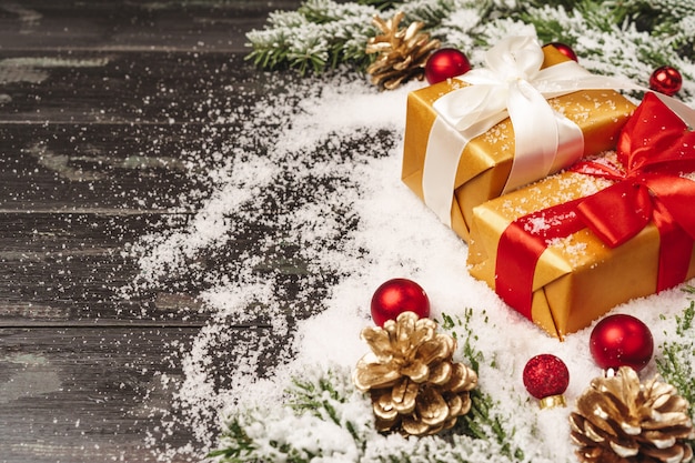 Beautiful Christmas gift with snowy holiday decorations on table