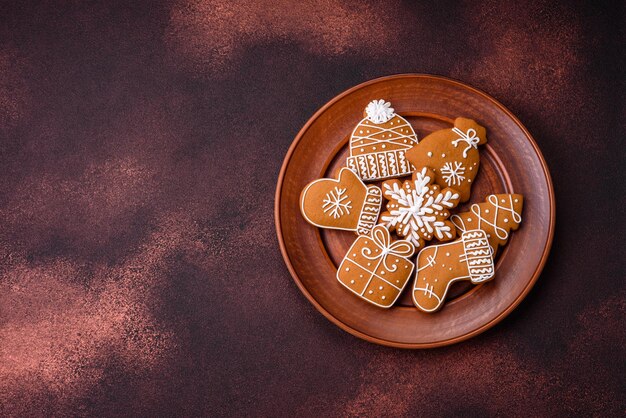 Photo beautiful christmas gingerbread cookies of different colors on a ceramic plate