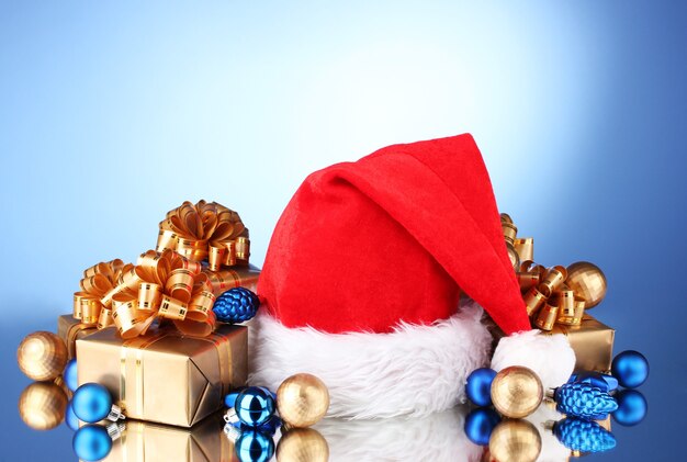 Beautiful Christmas hat, gifts and Christmas balls on blue  background