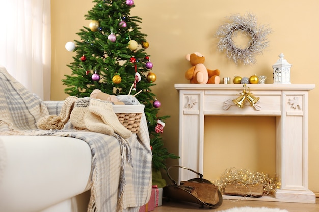 Beautiful Christmas interior with decorative fireplace and fir tree