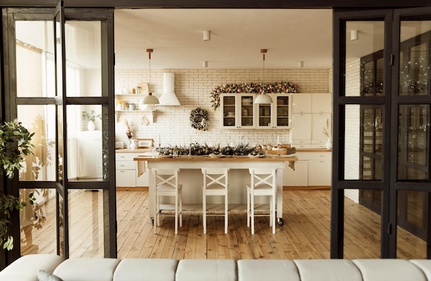 Foto bella cucina di natale con un grande tavolo e un sacco di decorazioni di natale tavolo festivo in cucina in attesa di ospiti