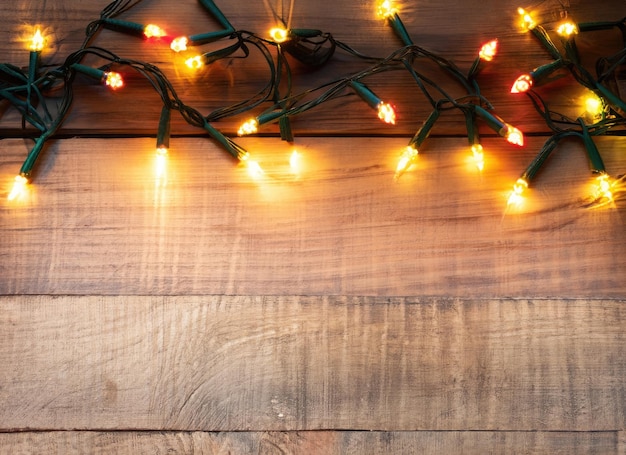 Photo beautiful christmas light on wooden background ai generated