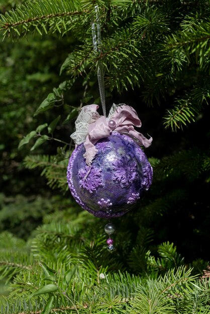 Beautiful Christmas or New Year's toy hanging on a spruce branch closeup in the forest