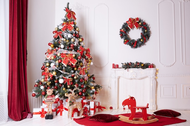 Bellissimo albero di natale decorato con fiocchi e palline al chiuso.