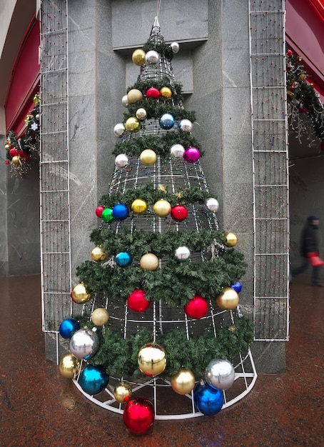 Photo beautiful christmas tree, decorated with colorful balls set in the city