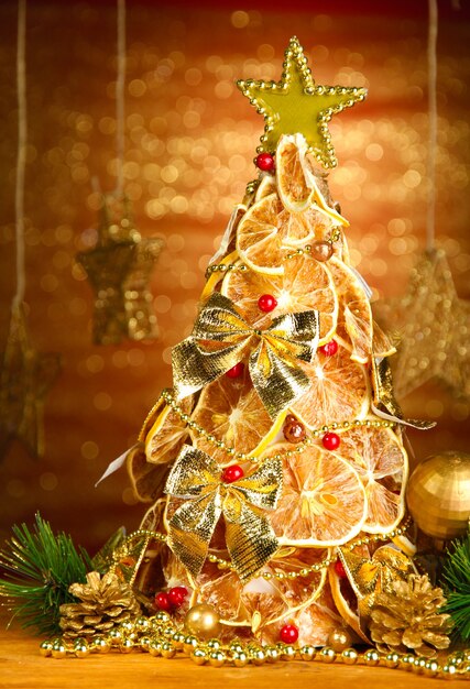 빛나는 배경에 장식이 있는 마른 레몬의 아름다운 크리스마스 트리