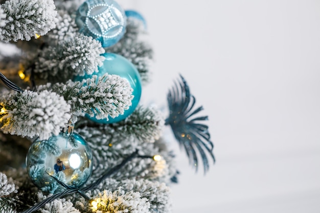 Bellissimo albero di natale all'interno di uno studio fotografico, camera da letto, decorazione di capodanno invernale. palline blu giocattoli di natale. il nuovo anno è presto