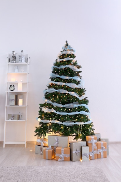 Beautiful Christmas tree with gift boxes in interior of living room