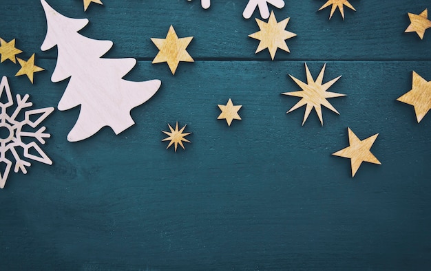 The beautiful christmas with lots of small wooden decorations on the dark wooden desk.