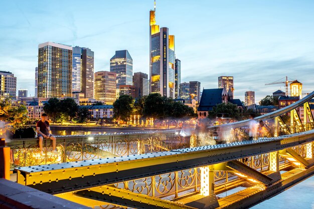 Beautiful cityscape view on the illuminated skyscrapers and bridge during the twilight in Frankfurt, Germany