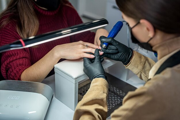 Una bellissima cliente è venuta al salone di bellezza per una nuova manicure durante la pandemia