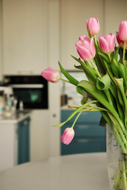 Beautiful closeup of bouquet of pink delicate tulips at kitchen Holiday floral decor Copy space