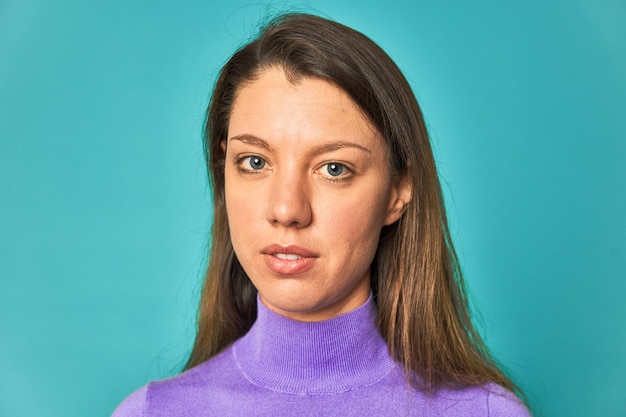 Beautiful closeup portrait of a Caucasian woman with blue eyes looking at the camera in a studio