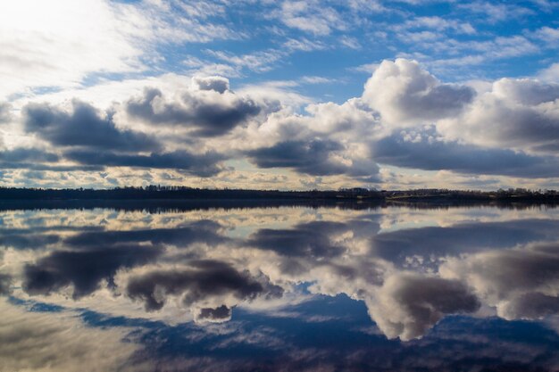 Belle nuvole sul cielo blu e riflesso nell'acqua