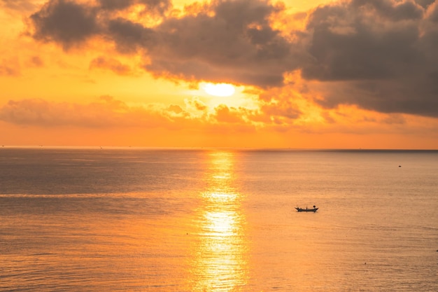 海の上の美しい雲景ショット 日の出のショット 孤独なボート 夕焼け空と雲の切れ間から太陽が沈む穏やかな海 夕焼け空または日の出と雲の切れ間から太陽が沈む穏やかな海