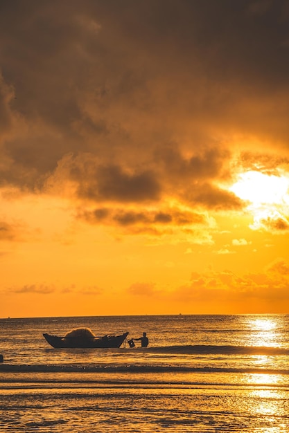 Beautiful cloudscape over the sea sunrise shot Lonely boats Calm sea with sunset sky and sun through the clouds over Calm sea with sunset sky or sunrise and sun through the clouds over