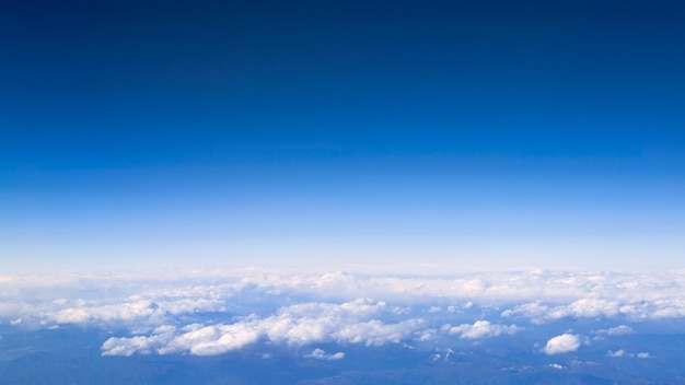 青い空とプロモーションテキストや広告のためのスペースをコピーするための美しい雲景飛行機の窓から見た白い雲の上の素晴らしいパノラマ空の旅のコンセプト