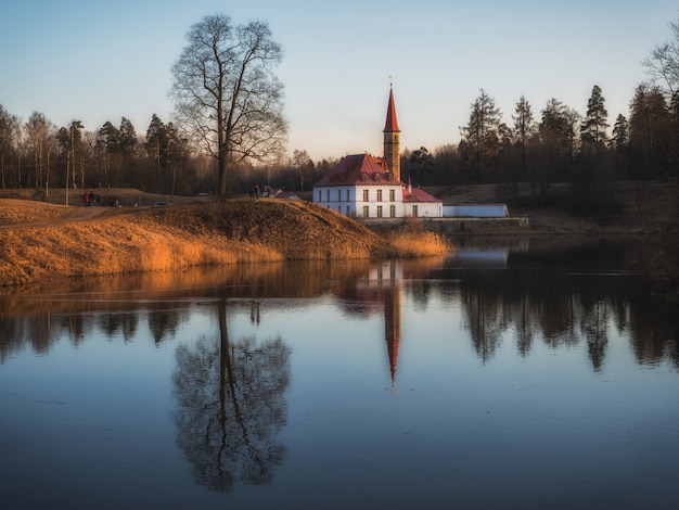 Photo beautiful color landscape with a blue lake an old castle and reflections in the water in early spring