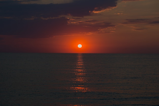 夏の海に沈む美しい色の夕日