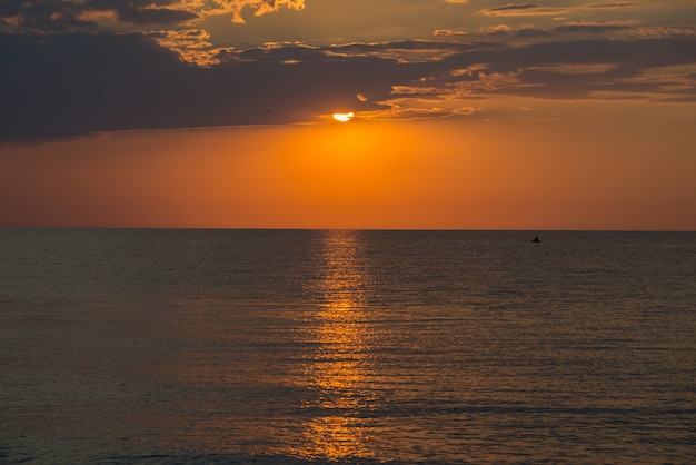 夏の海に沈む美しい色の夕日