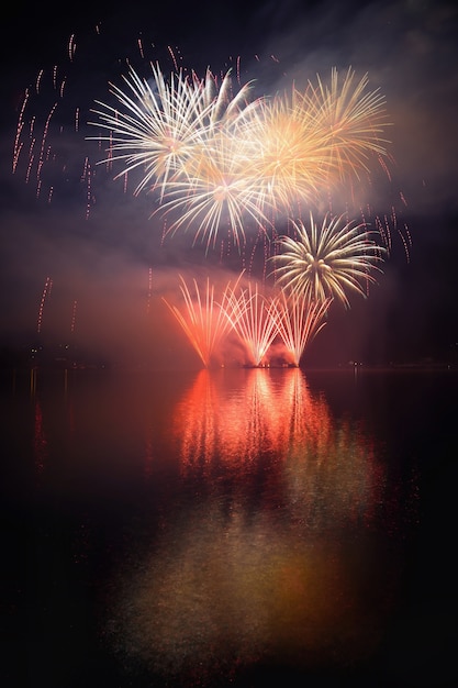 Beautiful colorful fireworks on the water surface with a clean black background. Fun festival and international contest of Firefighters from all over the world Ignis Brunensis 2017. Brno Dam - Czech Republic.