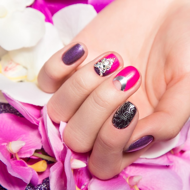 Beautiful colorful manicure with bubbles and crystals on female hand Closeup Picture taken in the studio