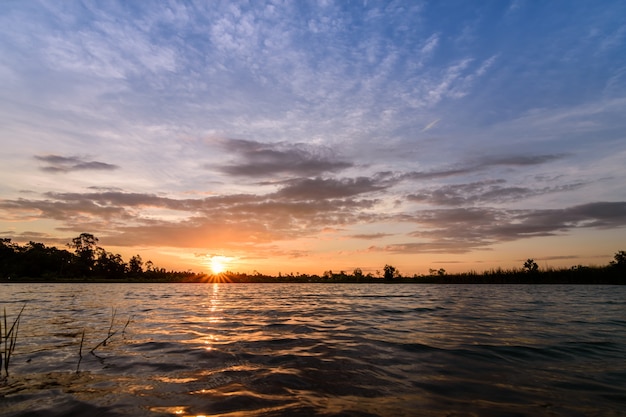 Beautiful colorful orange sky at sunset over the lake.