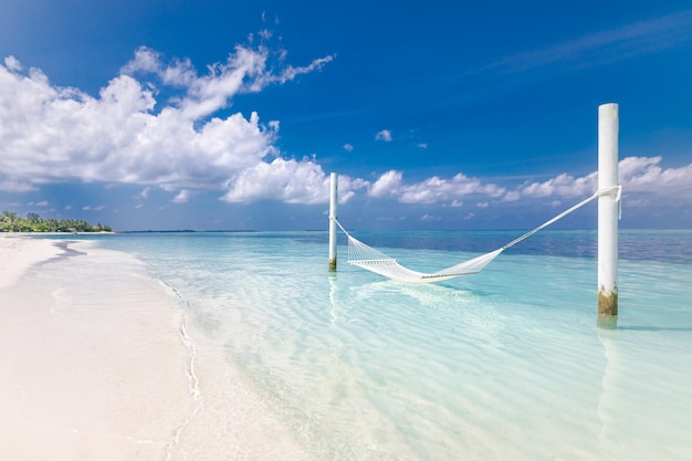 Beautiful colorful seascape with white hammock and white sand on a beach. Paradise island concept