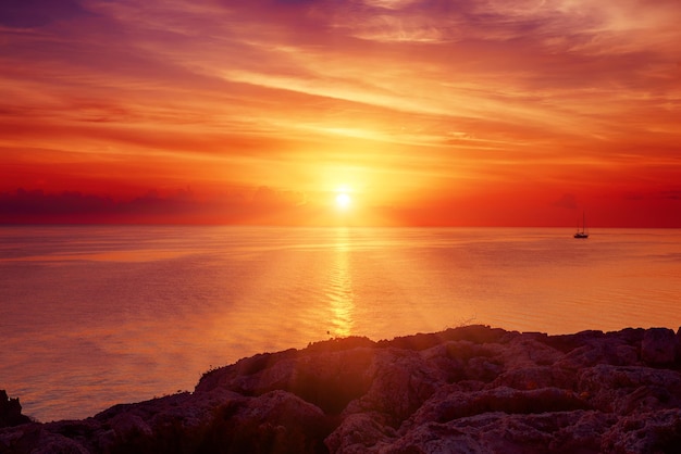 Красивый красочный восход солнца на море с драматическими облаками и сияющим солнцем