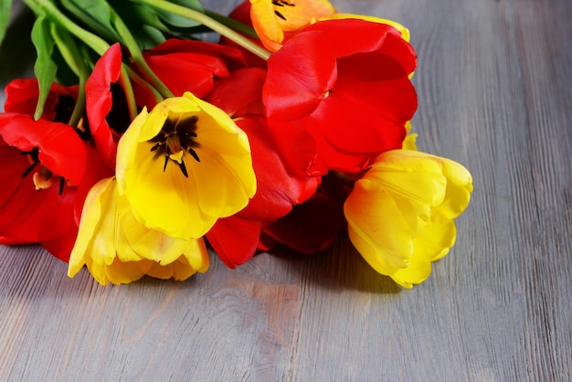 Beautiful colorful tulips on wooden table closeup