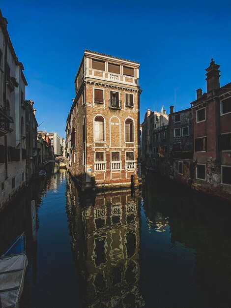 Beautiful and colorful venetian front house surrounded by water during sunset