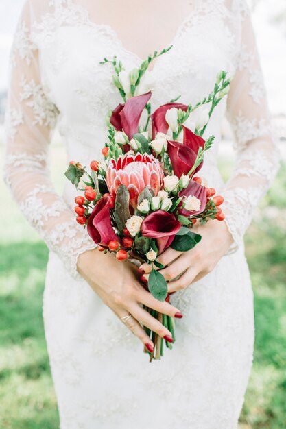 Photo beautiful colorful wedding bouquet in woman hands.