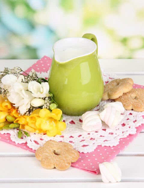 Photo beautiful composition of milk and cookies on wooden picnic table on natural background