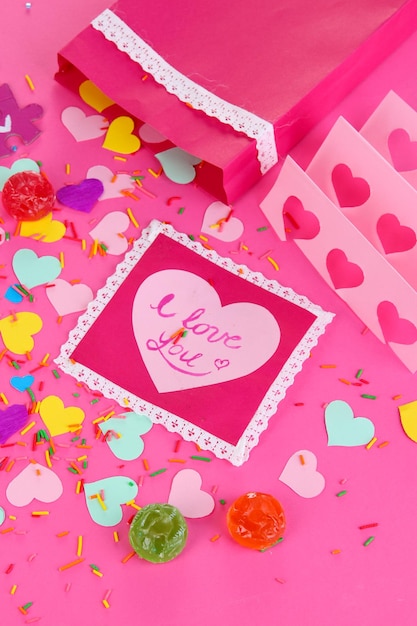 Beautiful composition of paper valentines and decorations on pink background close-up