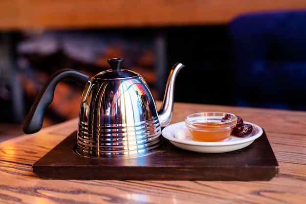 Bella composizione di una teiera per il tè una tazza rossa e un piattino con miele