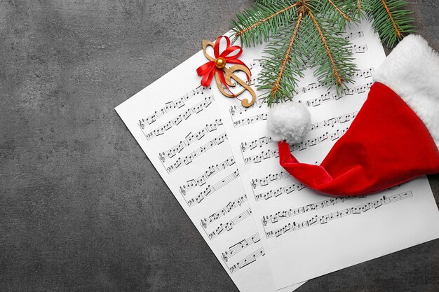 Beautiful composition with decorations and music sheets on grey background. Christmas songs concept