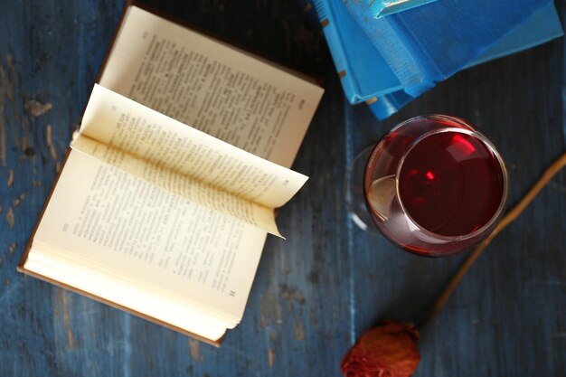 Foto bella composizione con bicchiere di vino con vecchi libri sul tavolo da vicino