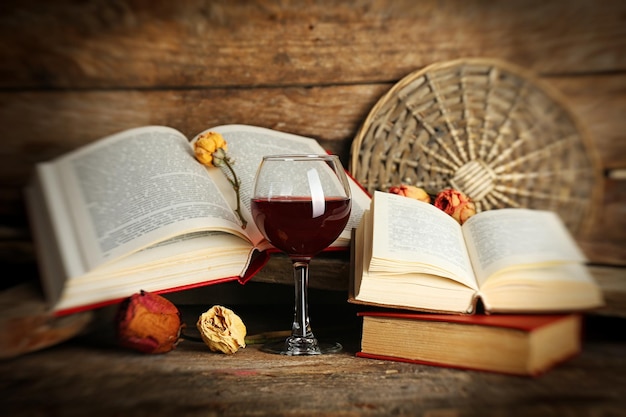 beautiful composition with glass of wine with old books on table close up