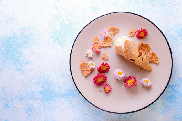 Foto bellissima composizione con gelato e fiori su sfondo blu