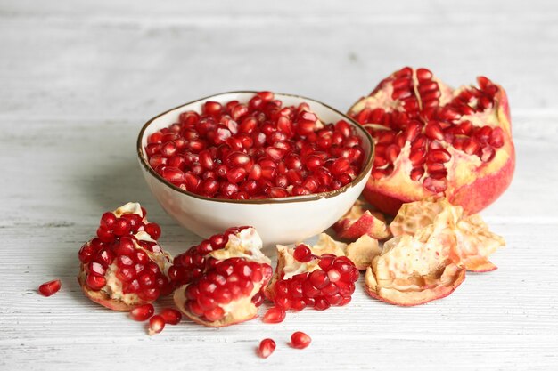 Beautiful composition with juicy  pomegranate seeds, on old wooden table