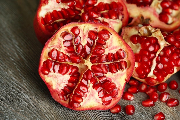 Photo beautiful composition with juicy pomegranates on old wooden table