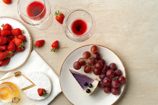 Beautiful composition with strawberry, grapes, cheese and blueberry cheesecake top view