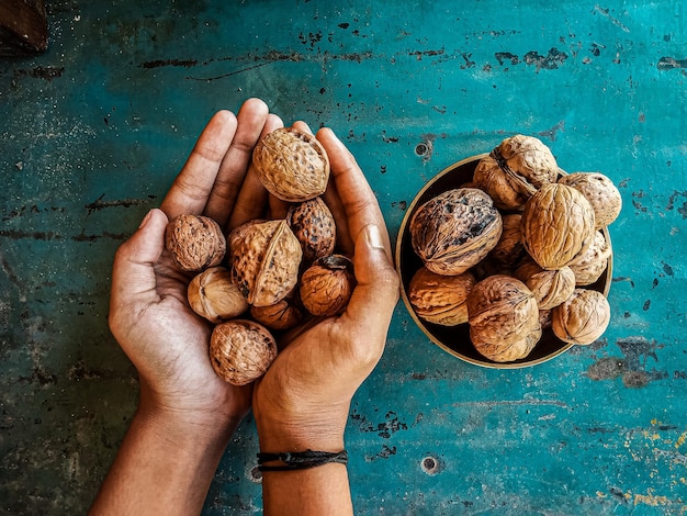 Beautiful composition with walnuts on the sackcloth. Nuts on the table or walnut on golden bowl with