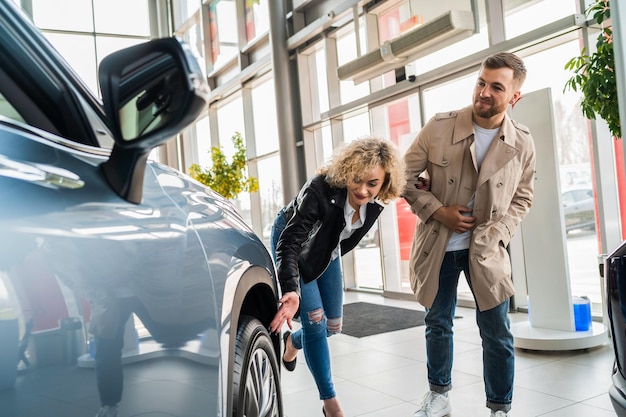 Beautiful couple in car dealership chooses car