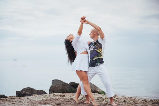 Photo beautiful couple dancing on the beach at the background