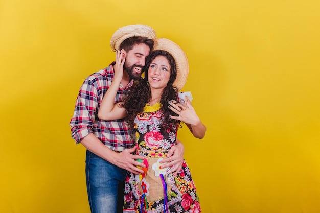 페스타 Junina Arraia de Sao Joao를 위해 전형적인 옷을 입은 아름다운 커플 포옹 미소