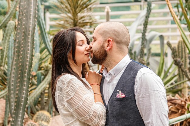 Beautiful couple girl and guy in the park among tropical trees