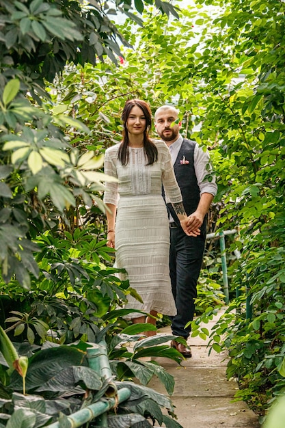 Beautiful couple girl and guy in the park among tropical trees