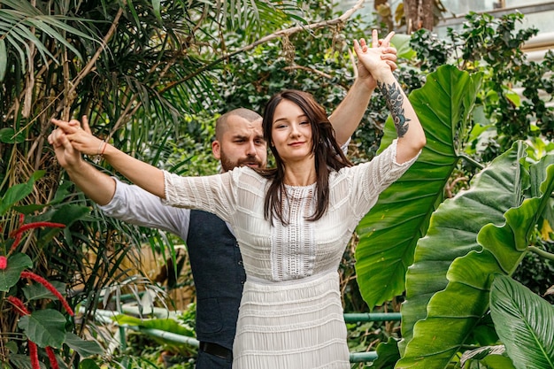 Красивая пара девушка и парень в парке среди тропических деревьев